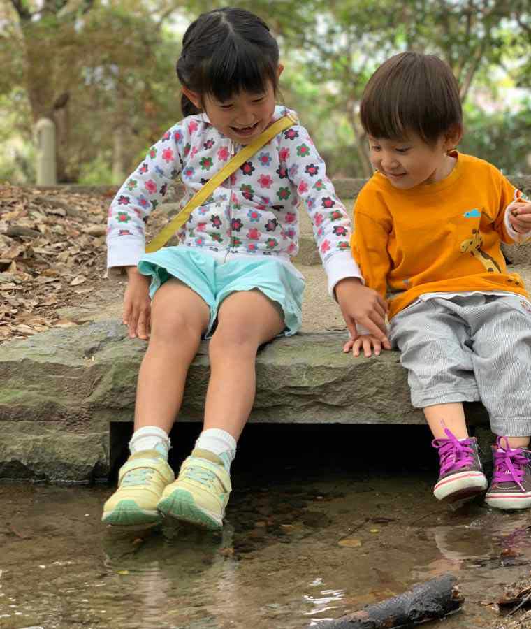 流れる小川で遊ぶ子どもたち