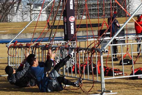 重りを引っ張る障害物に挑戦する参加者