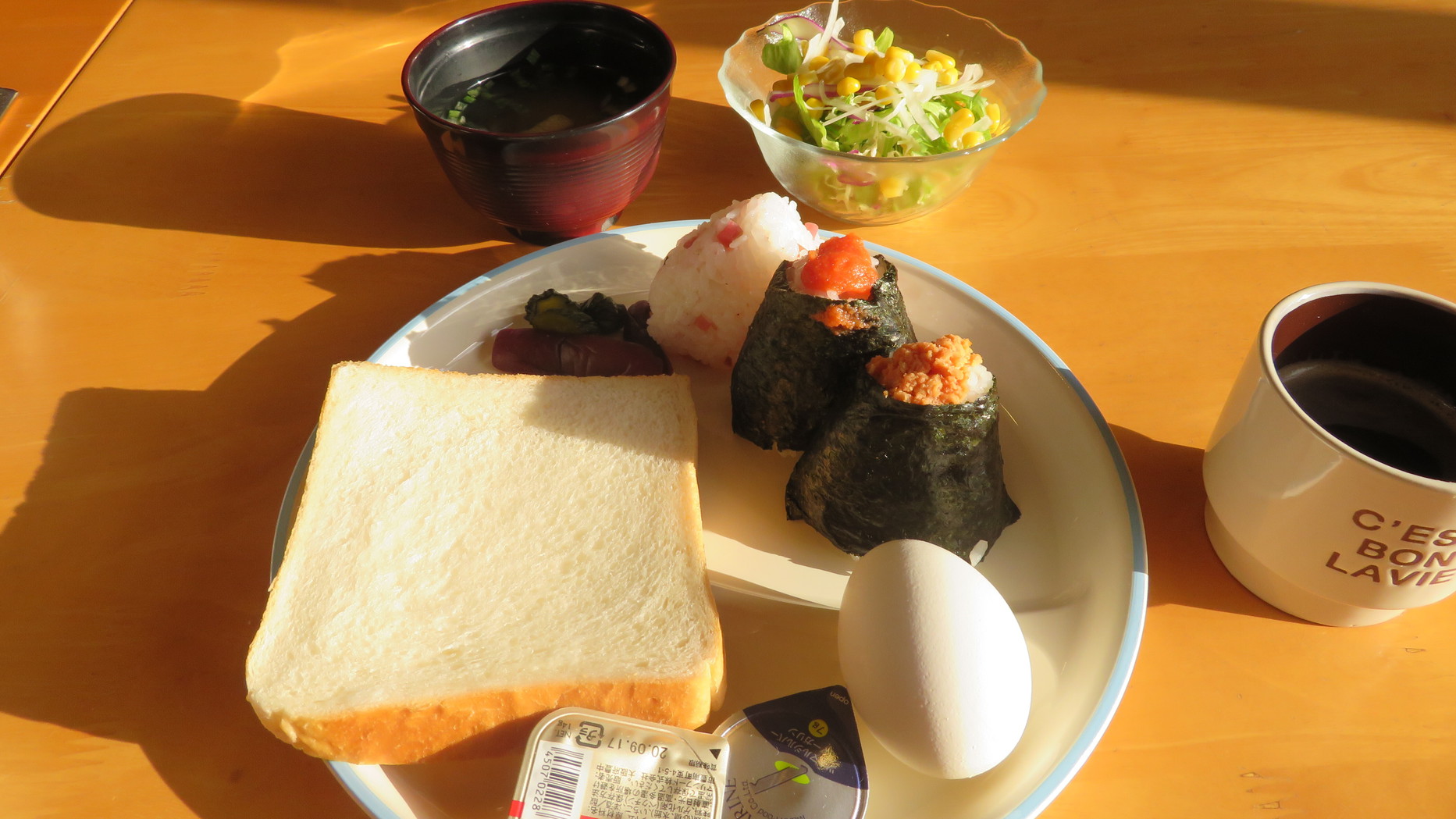 【無料軽朝食】の盛り付け例おにぎりコーヒー味噌汁サラダゆで卵等