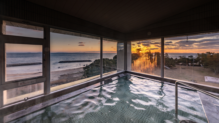 【大浴場−男湯】二面に広がる窓から、美しい朝陽がご覧いただけます。