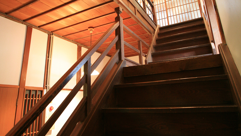 手すりの一部に水車の軸が使われている、古くて趣のある本館の階段
