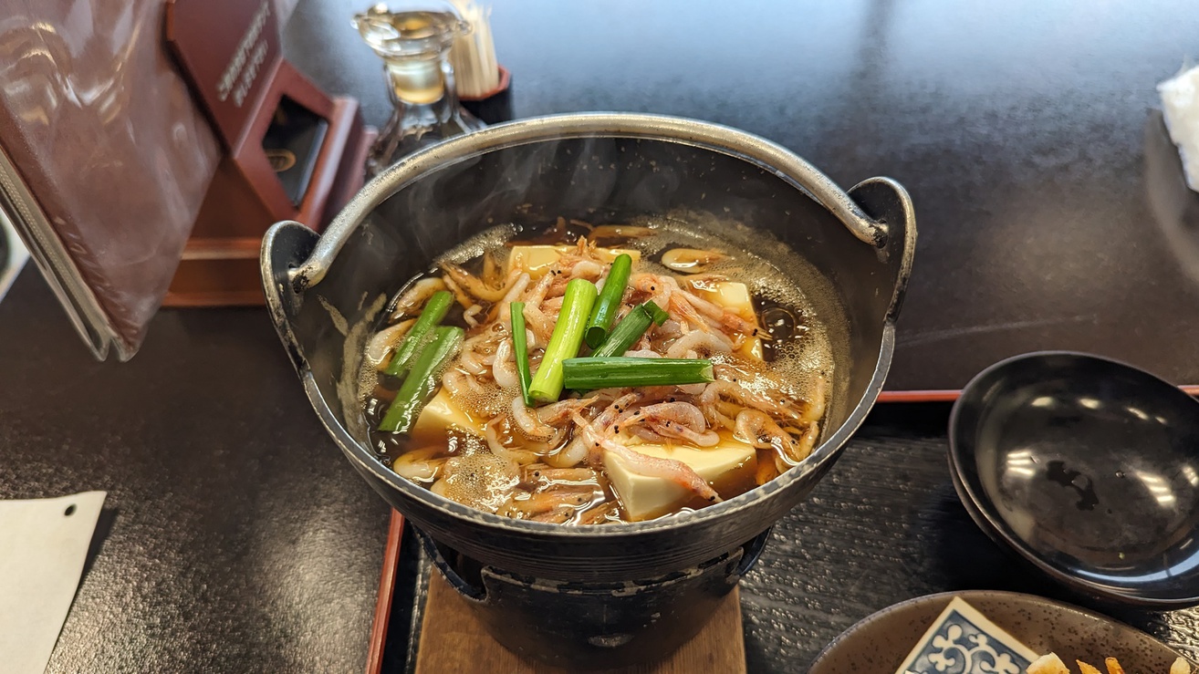 *料理一例／沖上がり（桜えび鍋）。桜えびに熱が入り旨味が増し、出汁となり豆腐と葱に染み込んだ味わい