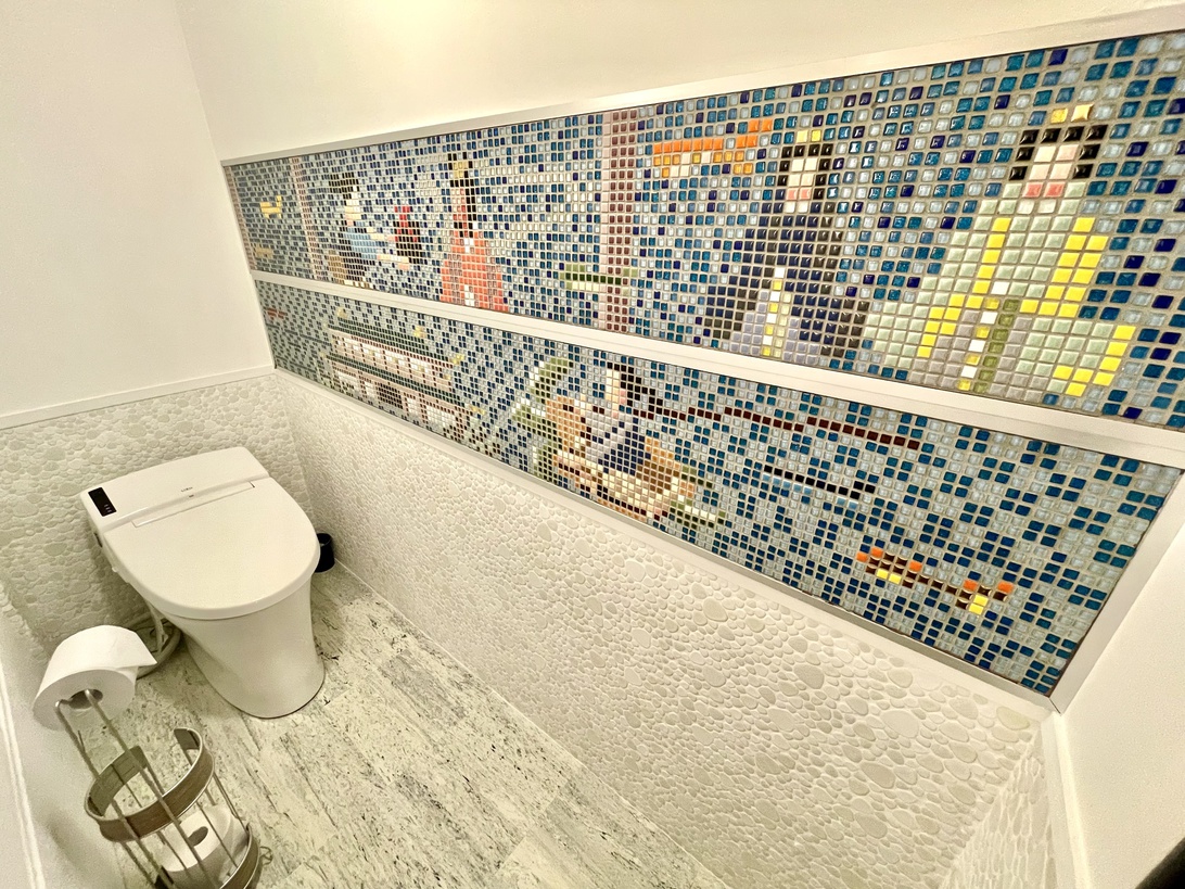 【洗面所】タイルアートで装飾された清潔感のあるトイレ。