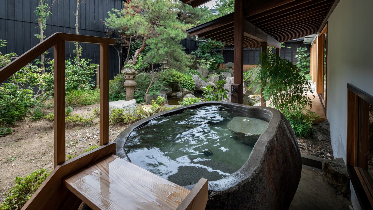 【KURA01】庭に面して蔵王石の巨石をくり抜いた露天風呂が設えられた客室