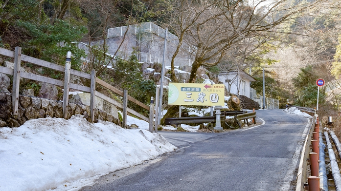 【*宿までの道のり】看板の手前で左へ大きくカーブしていただきますと、当館の駐車場となります。