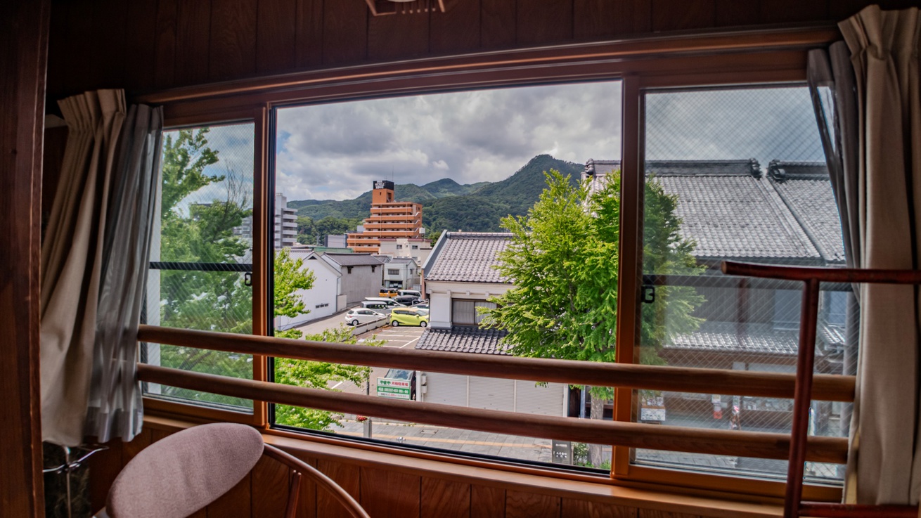 *客室一例（8畳）：通り沿いに面したとっておきのお部屋。朝夕行きかう人々や街並みを眺めて過ごすのも
