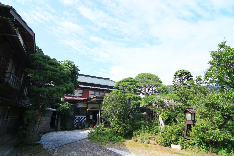 澄み渡った青空とお庭の緑が映える初夏の外観です。