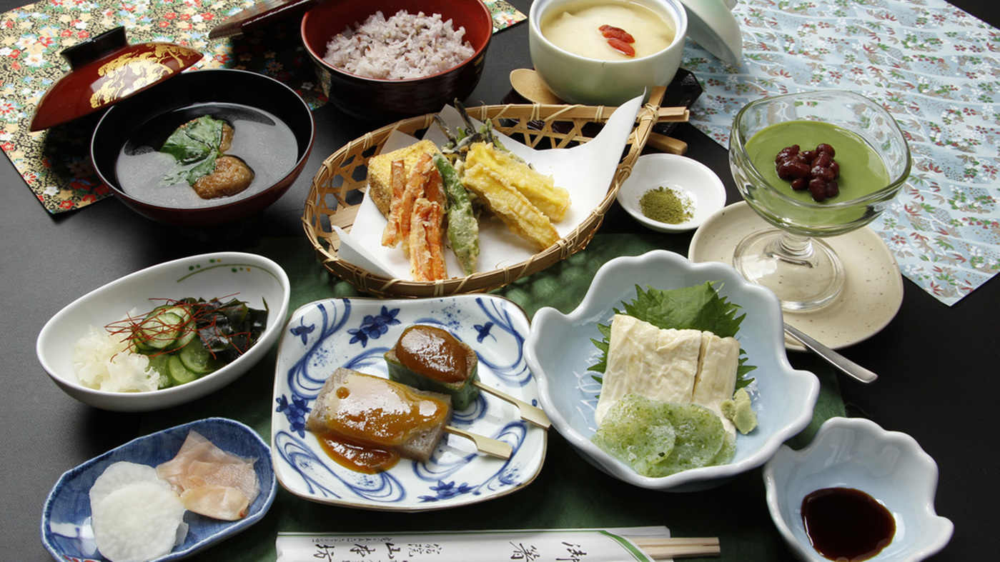 精進料理ご夕食一例になります。山菜の天ぷらやお豆腐など、身体に優しいお献立が並びます。