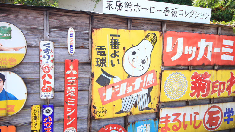 【看板コレクション】宿の駐車場の塀には、館主コレクションの懐かしい看板が♪