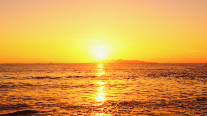 海と空がオレンジ色に染まる絶景の夕焼け