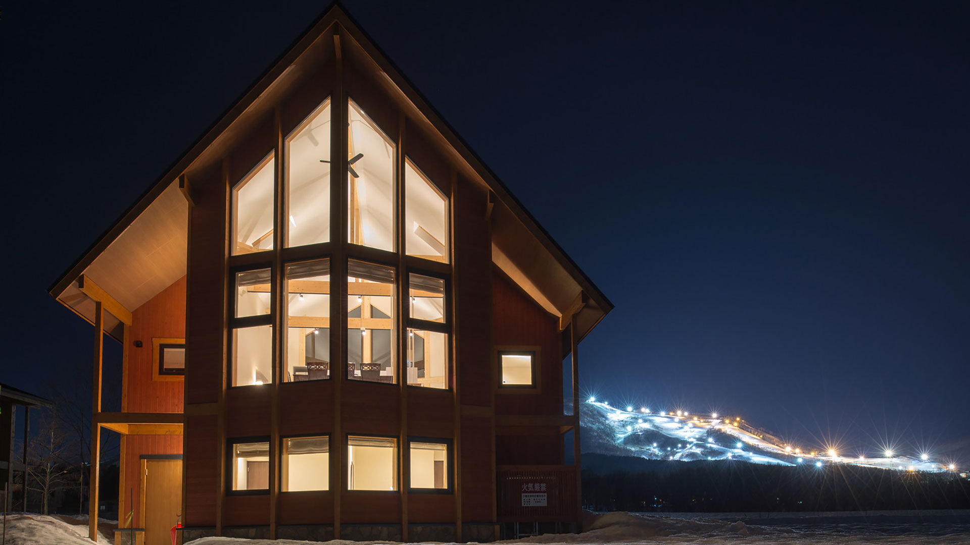 【3LDKスタンダード】外観(夜)。冬は近くのスキー場がライトアップされています。