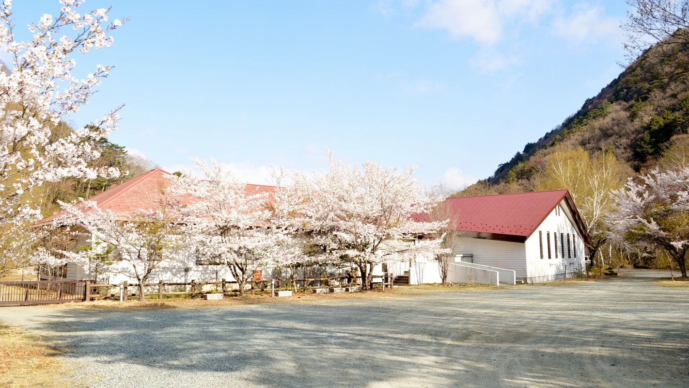 *外観/まだ肌寒い季節、青い空と桜の景色に包まれるヒュッテ。