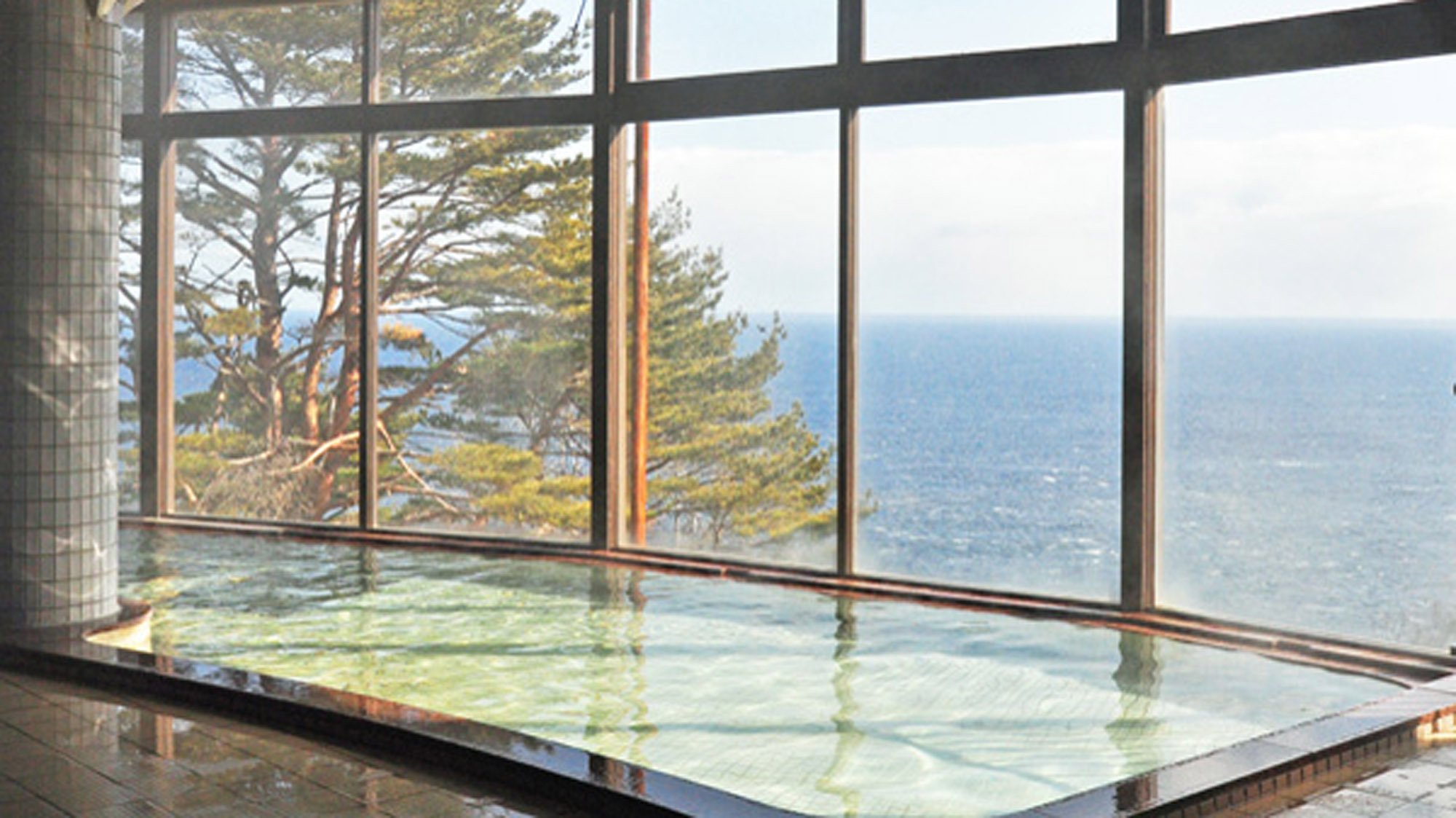 【展望大浴場】大きなガラス窓から紺碧の海と空が一望できます。絶景は冬場がおすすめです。