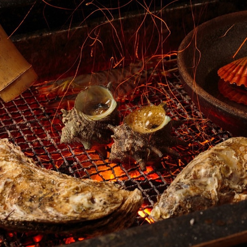 【磯遊び懐石】お客様の目の前で新鮮な魚介類を大きな囲炉裏を使って職人が丁寧に焼き上げます。