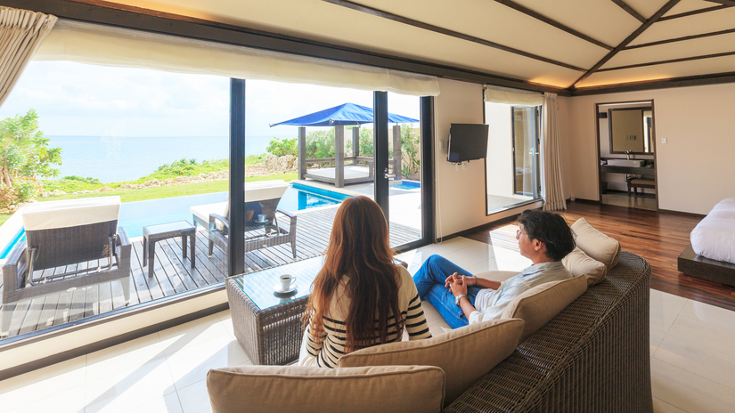 *【客室】広々としたリビングのソファからはテラスとプール・宮古島の海がご覧いただけます。