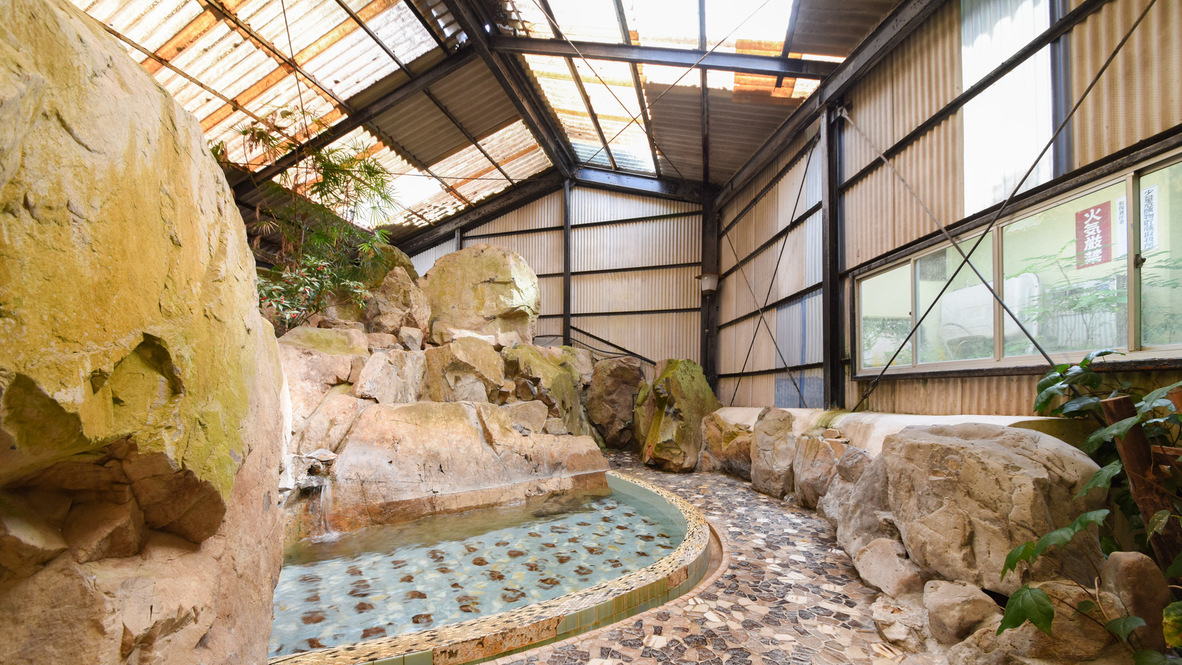 [岩風呂（夏季季節営業）]大きい岩に囲まれた扇型の浴槽です。
