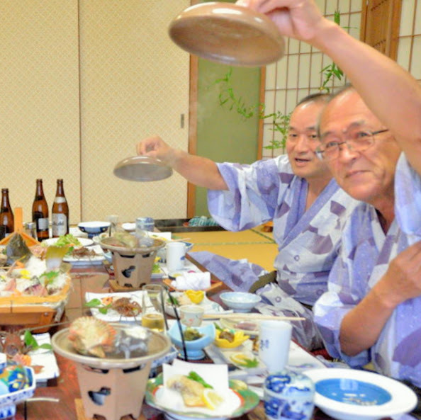 貝のホウロク焼きの蓋を開けるお客様