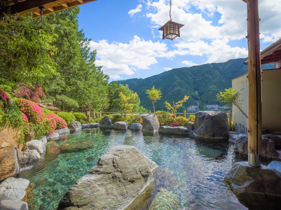 【露天風呂飛山之湯】自然に囲まれた当館の露天風呂。解放感あふれる景色と共に楽しむ。