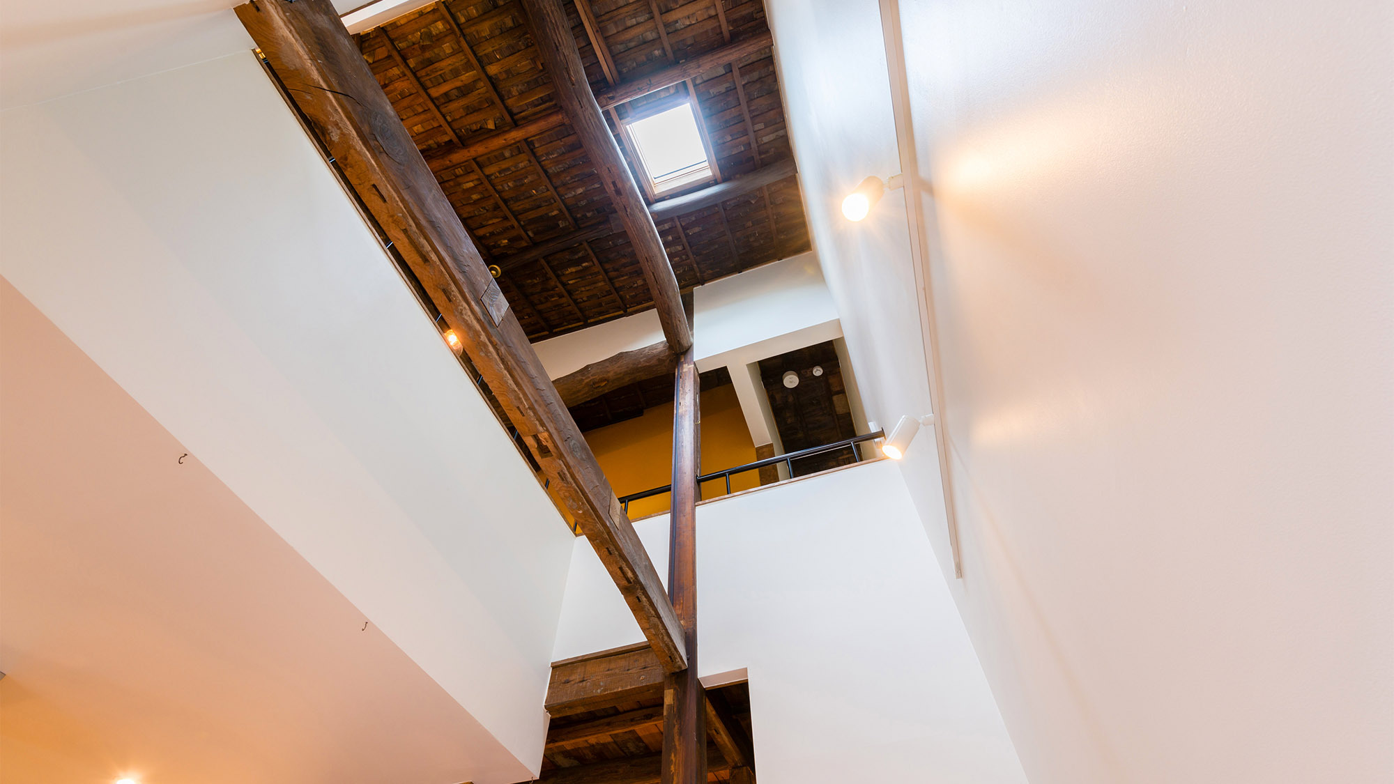 ・1階から2階の天井までの吹き抜け。天井や梁は昔の木材をそのまま使用しレトロな雰囲気に