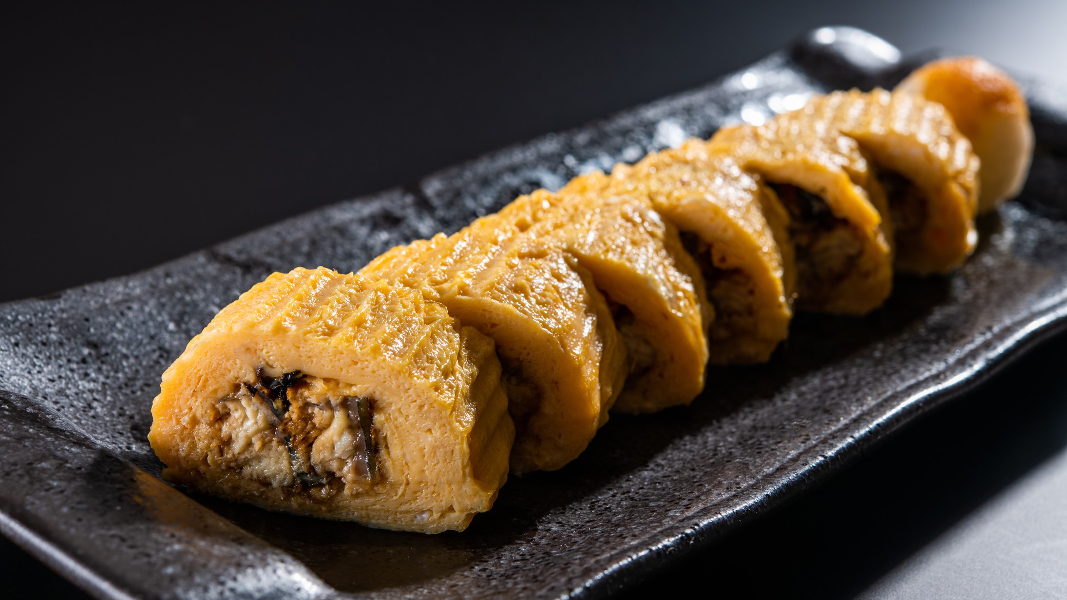 う巻き香ばしく焼き上げたうなぎの蒲焼きを、たっぷり出汁を効かせただし巻きで包んだ逸品。