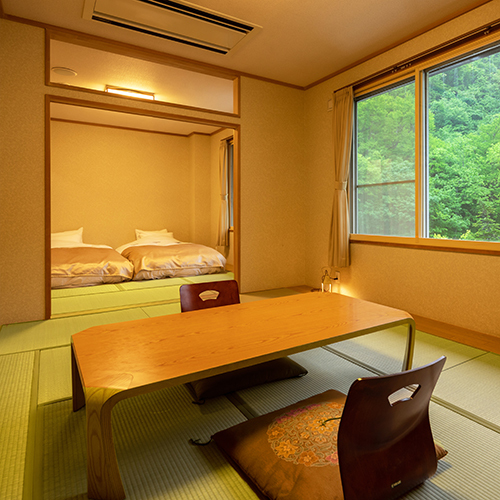 和室18畳ローベットでお布団よりも快適な睡眠を。大きな窓から見える森林に心和みます