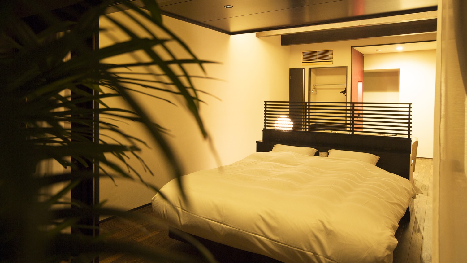 *【HIGASHI】窓に向けてクイーンベッドを設えた48平米の洋室。