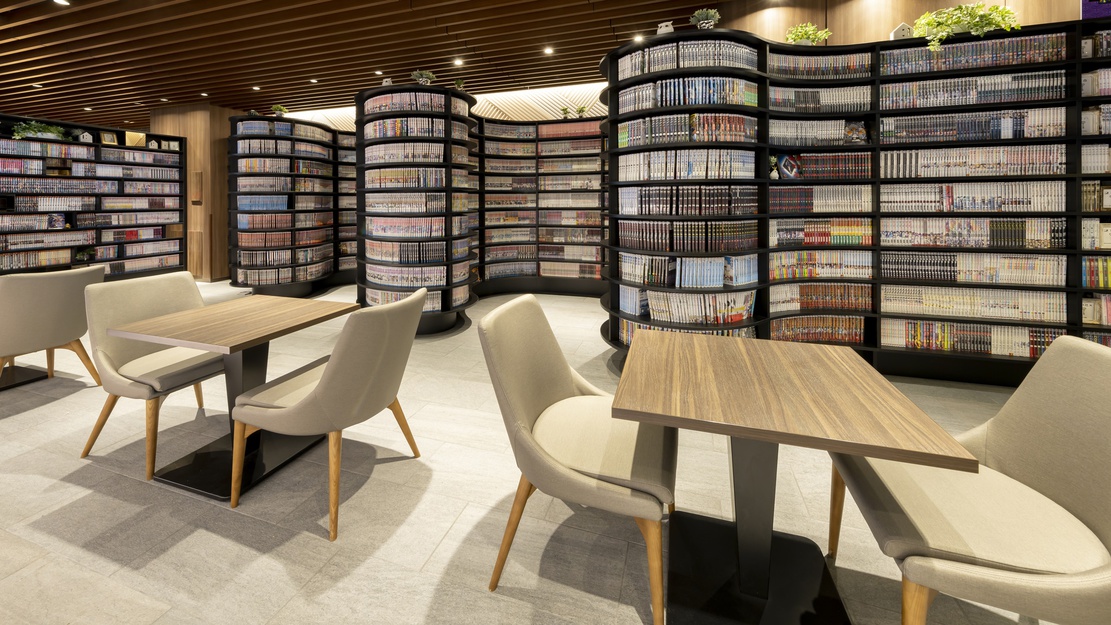 【MANGA Library】大きな壁一面に動きのある本棚を全面配置。