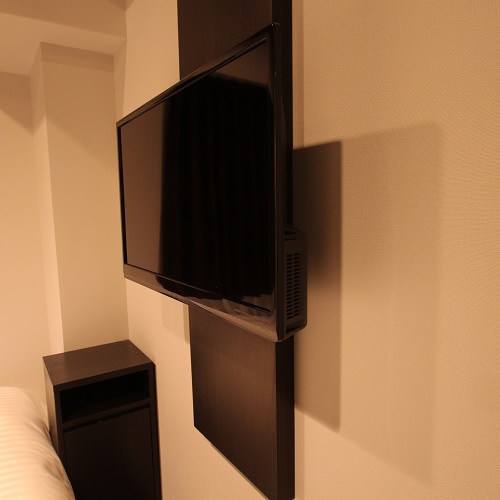 テレビ｜壁かけタイプのテレビ。ベッドで寛ぎながらお楽しみいただけます。