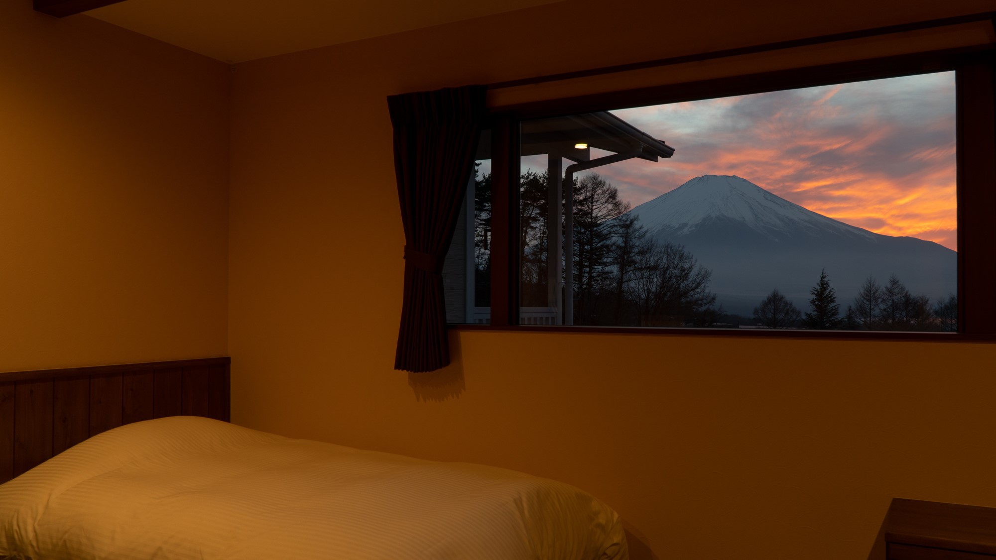 和モダンルーム—額縁のような大きな窓から見える夕焼けの富士山