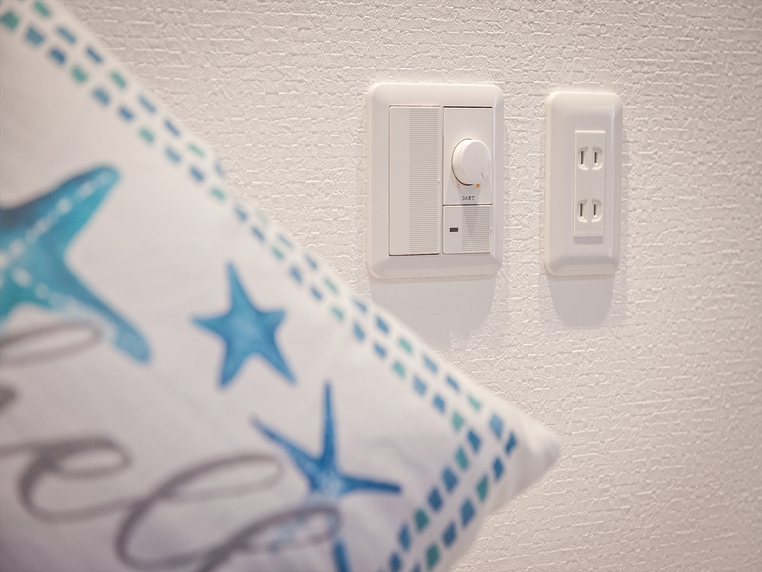ベッドサイドには便利なコンセントと調光スイッチを配置