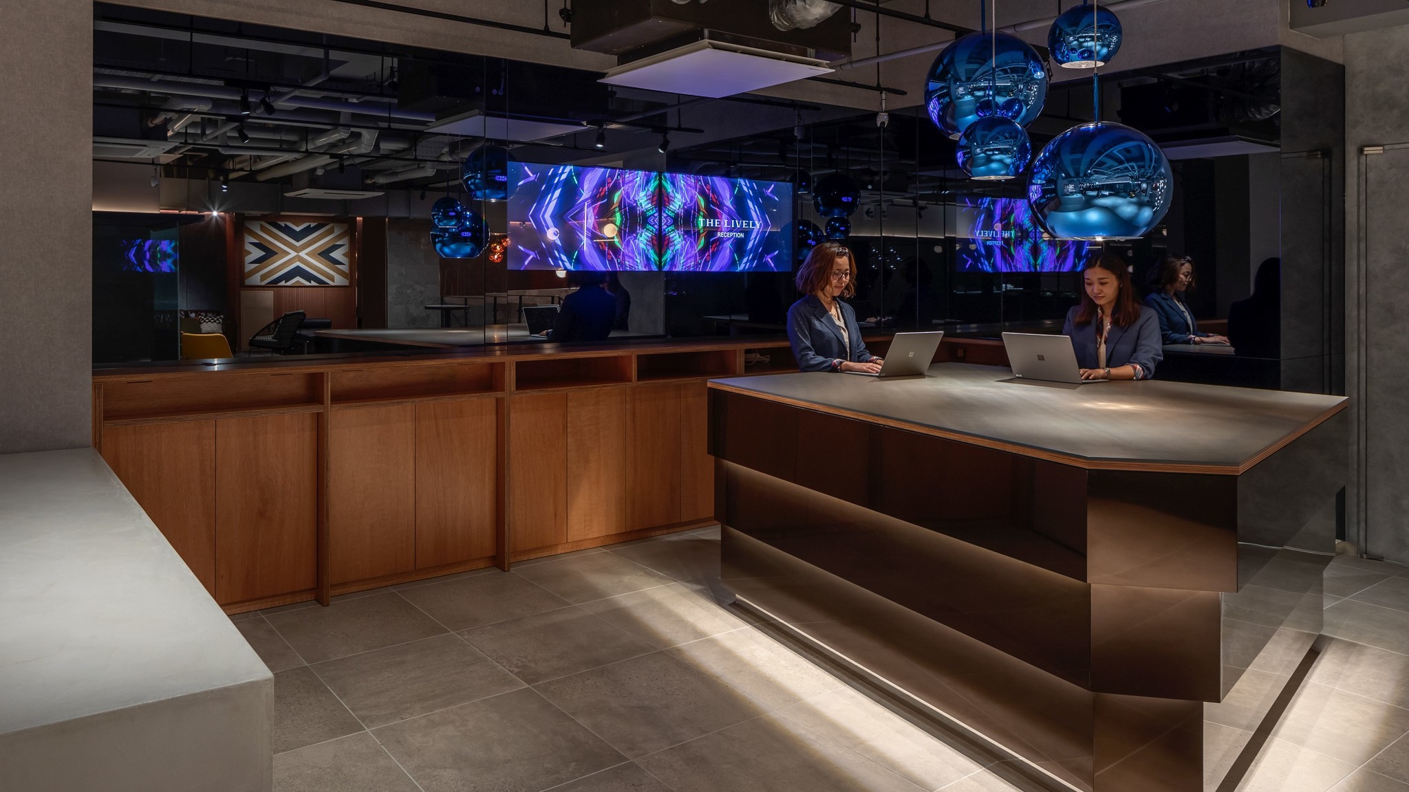 ブロンズとライティングで構成されたアイランド型のチェックインカウンター