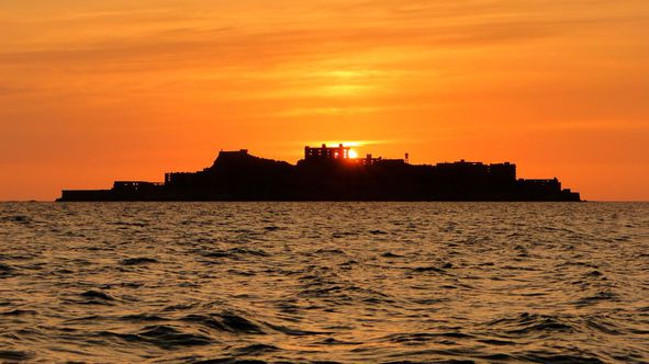 夕日を背に東シナ海に浮かぶ軍艦島