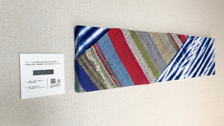 【客室】名古屋の伝統工芸品「有松絞り」と、地域の障がい者施設様による手織りがコラボしたアートパネル
