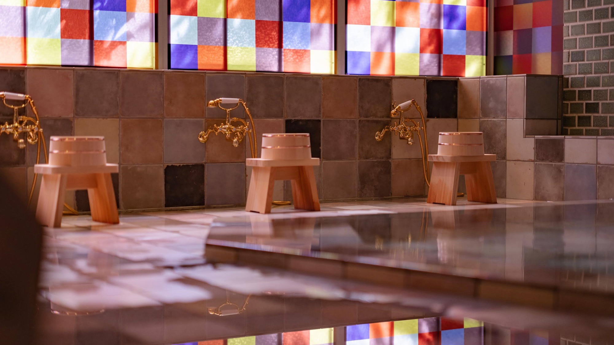【大浴場：明湯】パステルのタイルや鮮やかなステンドグラスをあしらった空間。
