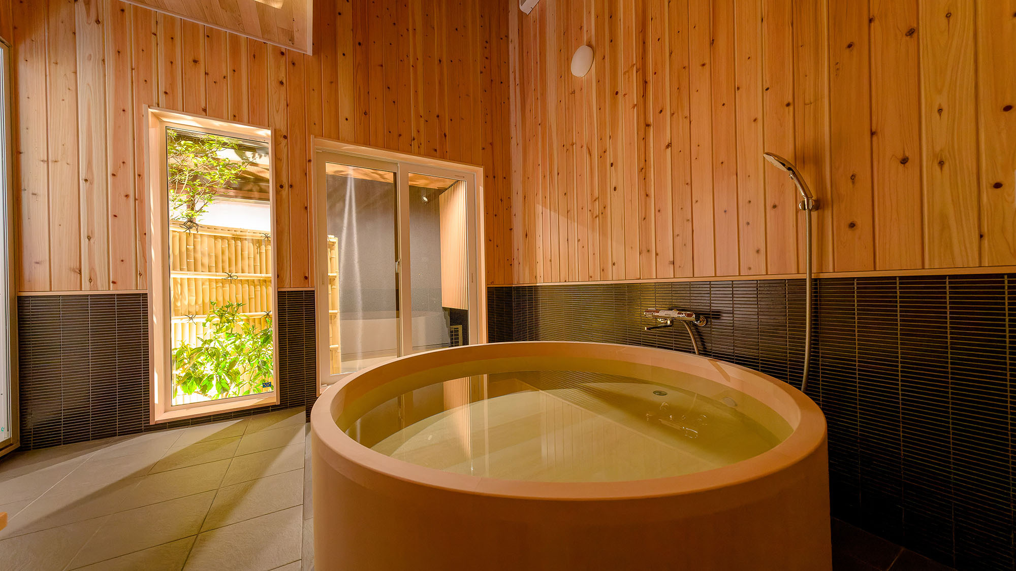 ・【鳳凰館・ヒノキ風呂】中庭と繋がっている半露天風呂タイプの檜風呂