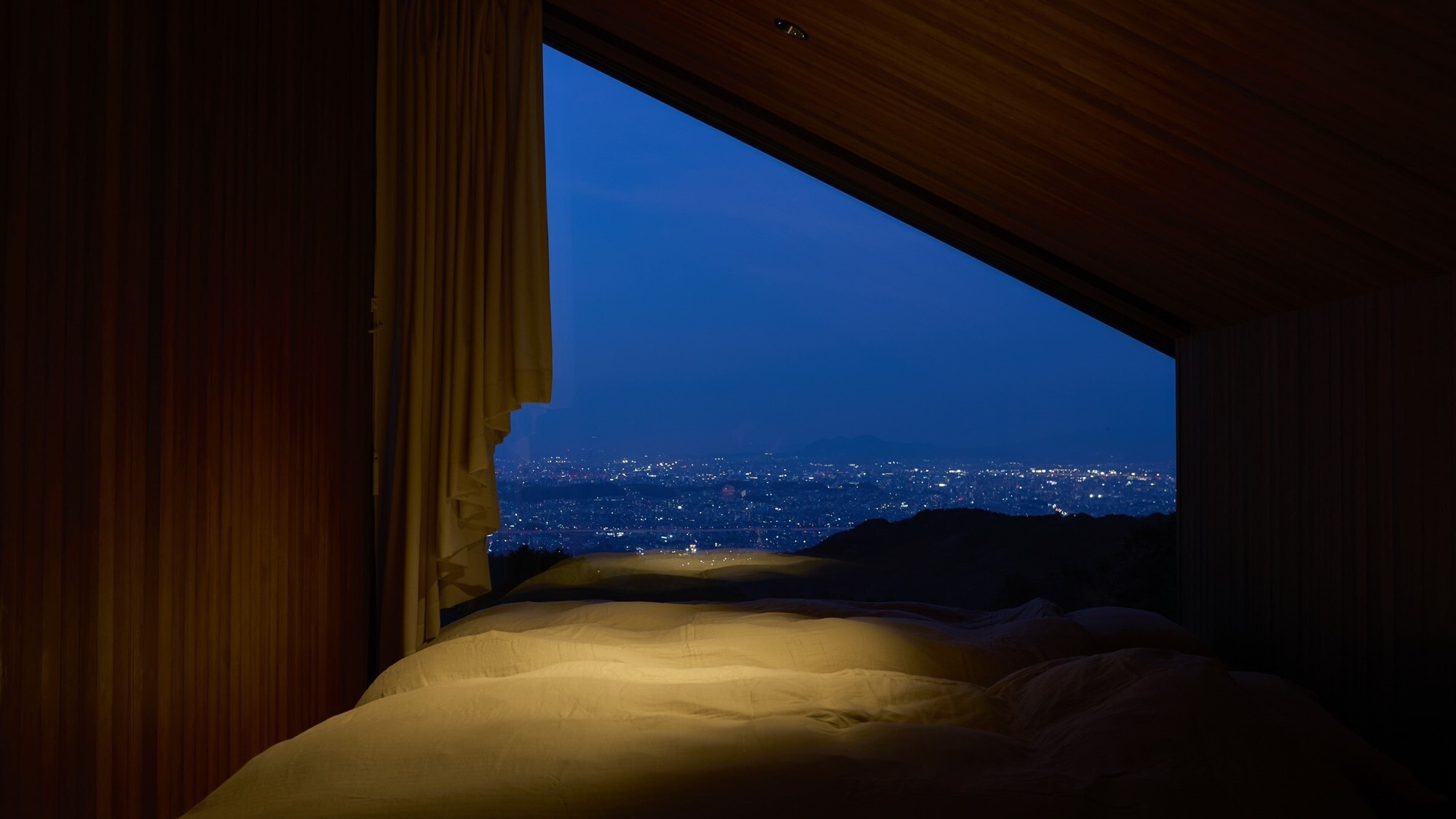 COTTAGE｜寝室の大きな窓ガラスから見える夜景を眺めながら眠りにつくことができます※イメージ