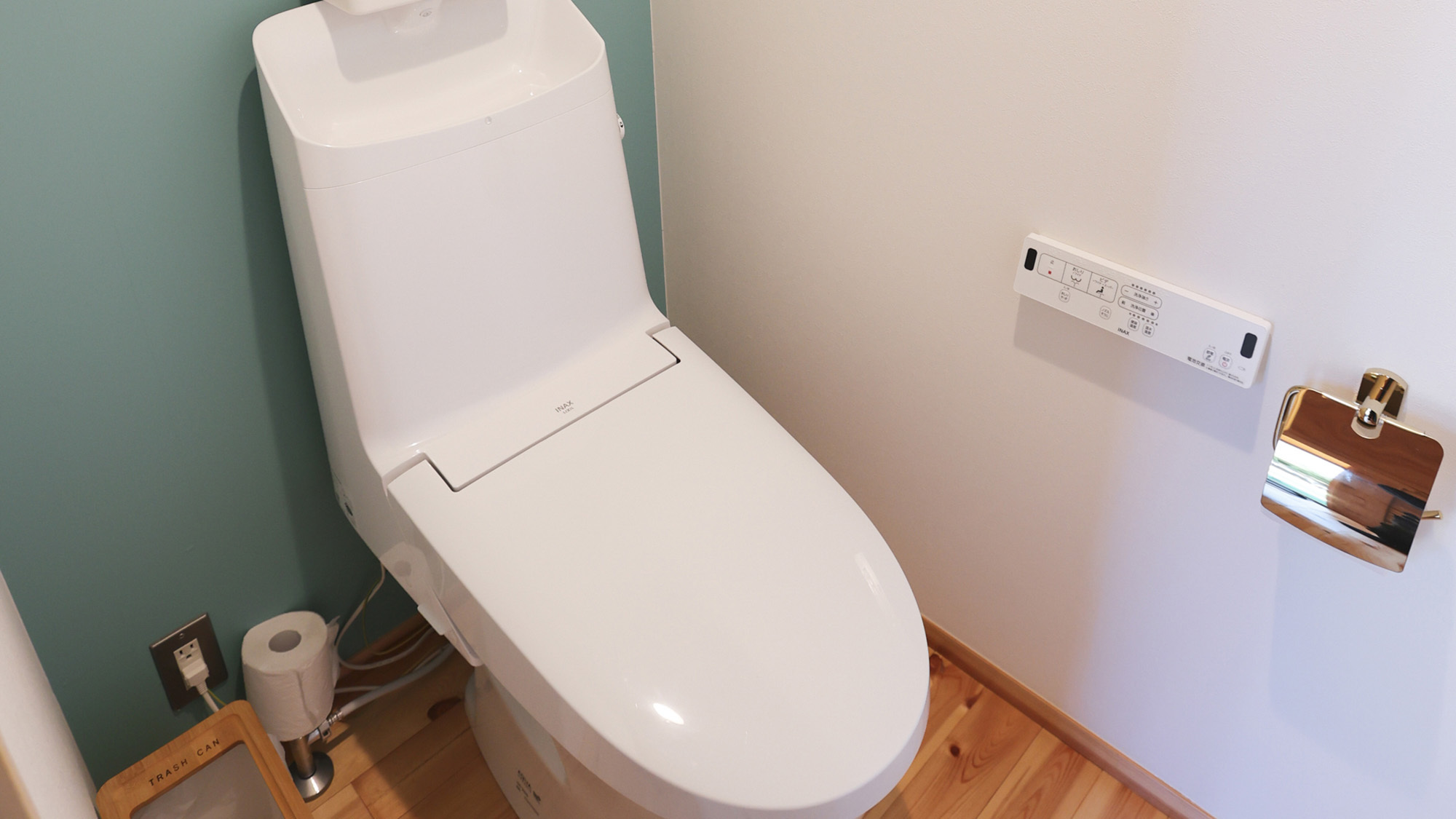 ・【トイレ一例】青い壁紙と外国風の油絵を飾っています。洗浄機能付きのトイレです。