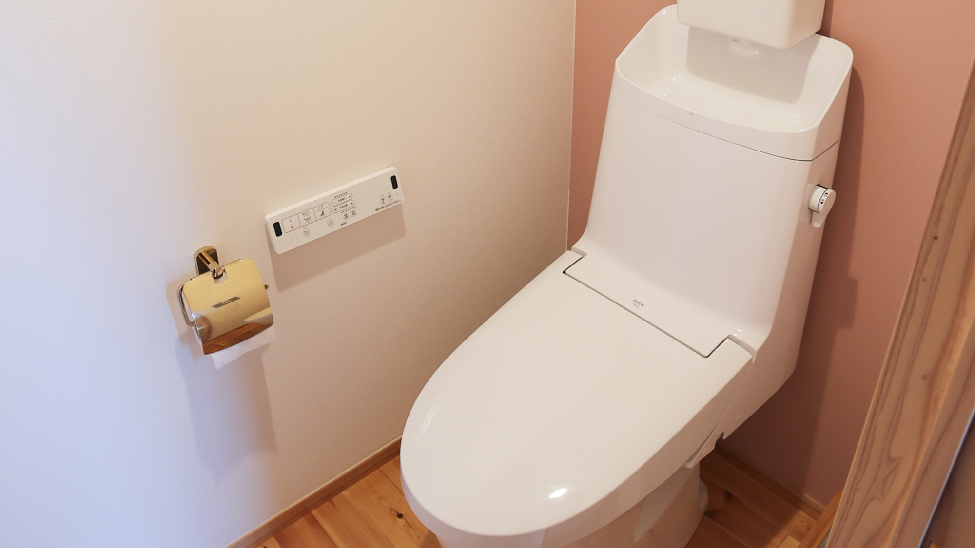 ・【トイレ一例】ピンクの壁紙とアメリカン風の油絵を飾っています。洗浄機能付きのトイレです。