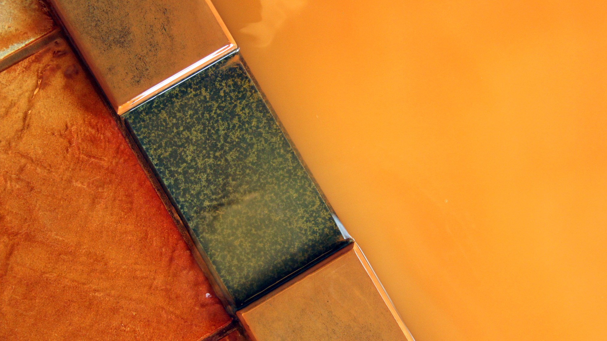 １階にある、木々に囲まれた秘湯風呂「岳」濃厚な赤褐色の秘湯がたっぷり注がれる湯舟。
