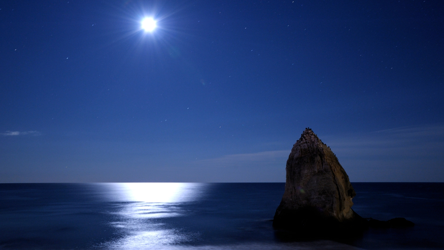  満月の夜、水平線から岸に向かい伸びる「月の道」。「月の道」と島が並ぶ風景は他では見られない絶景です