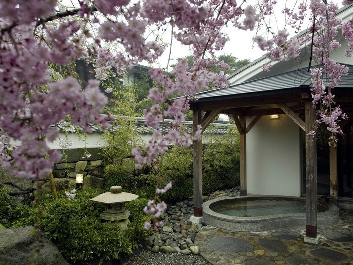 【白壁の湯】白壁を背景に、桜、椿、夏みかんなど季節の花を楽しむ大浴場、露天風呂。
