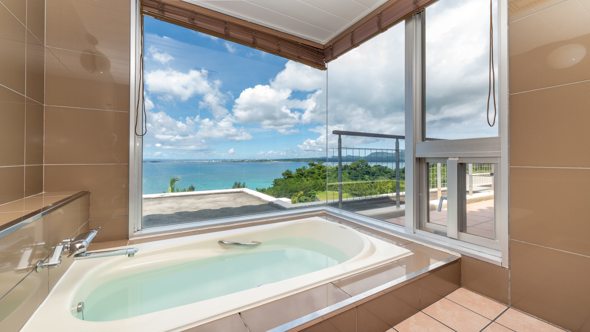 【アゼリアスイート】外の景色が楽しめる展望風呂。窓の向こうに広がる青い海。