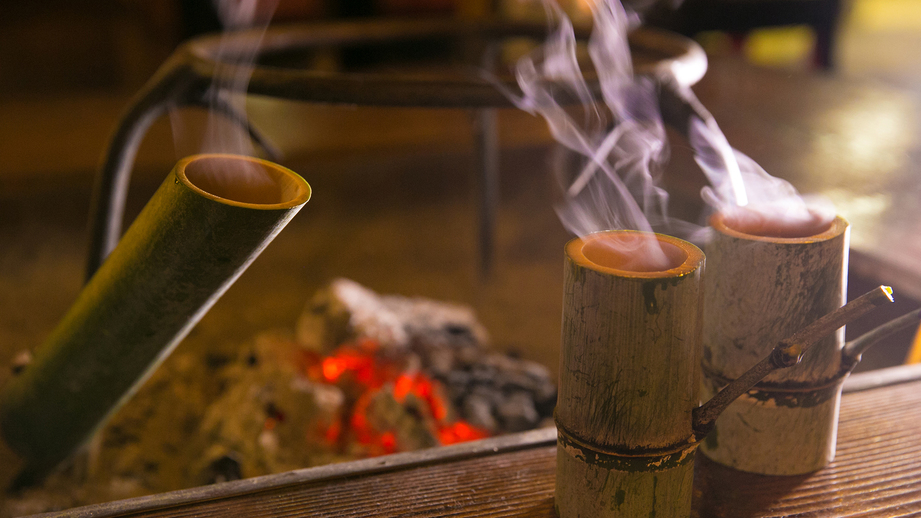 【館内施設】囲炉裏を囲んでいただく闊歩酒。青竹の油分が酒にしみ出て独特の風味に、笑顔がこぼれます。