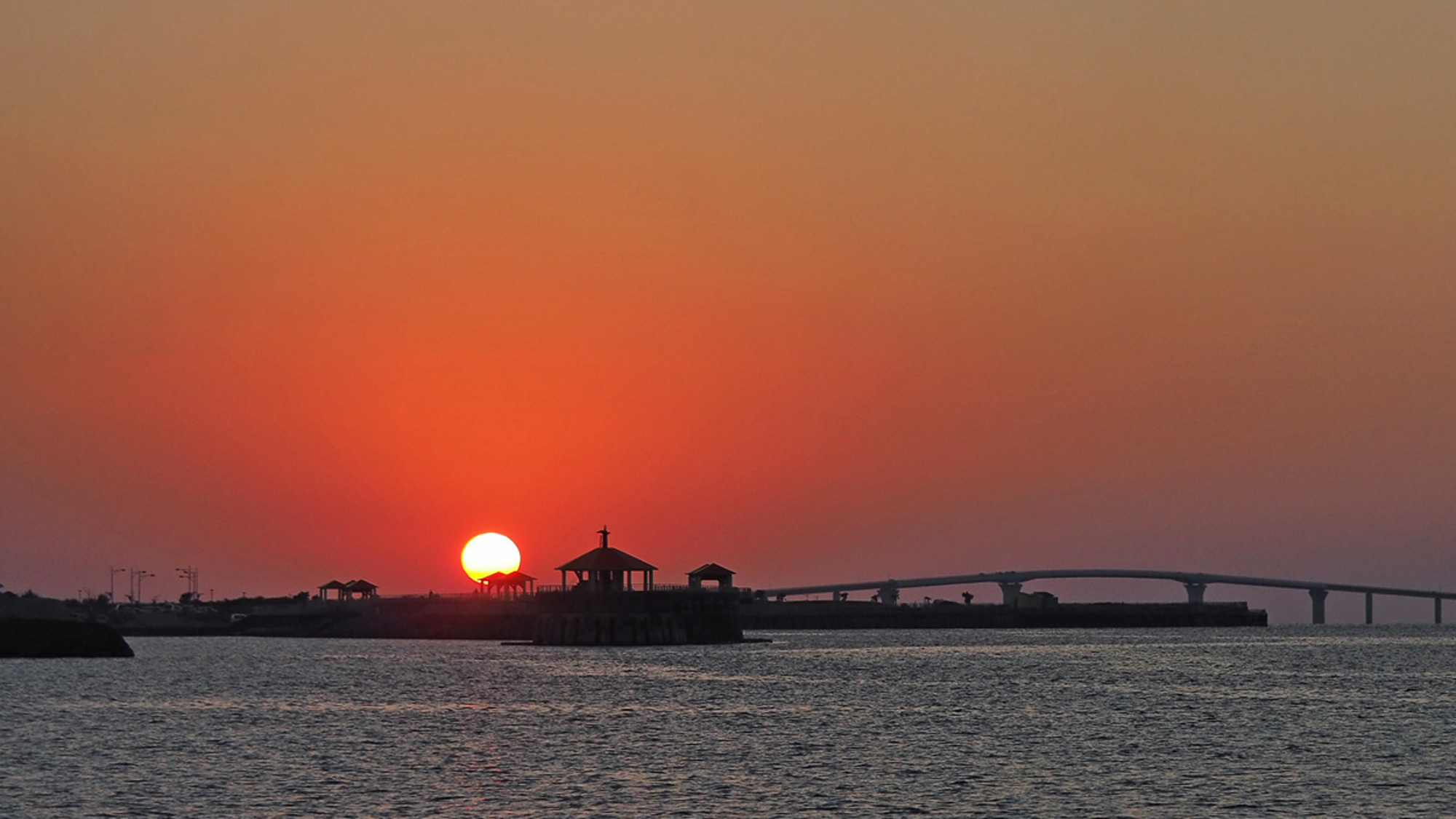 【サンセット】伊良部大橋と海へと沈む夕日。宮古島には夕日スポットがたくさんあります。