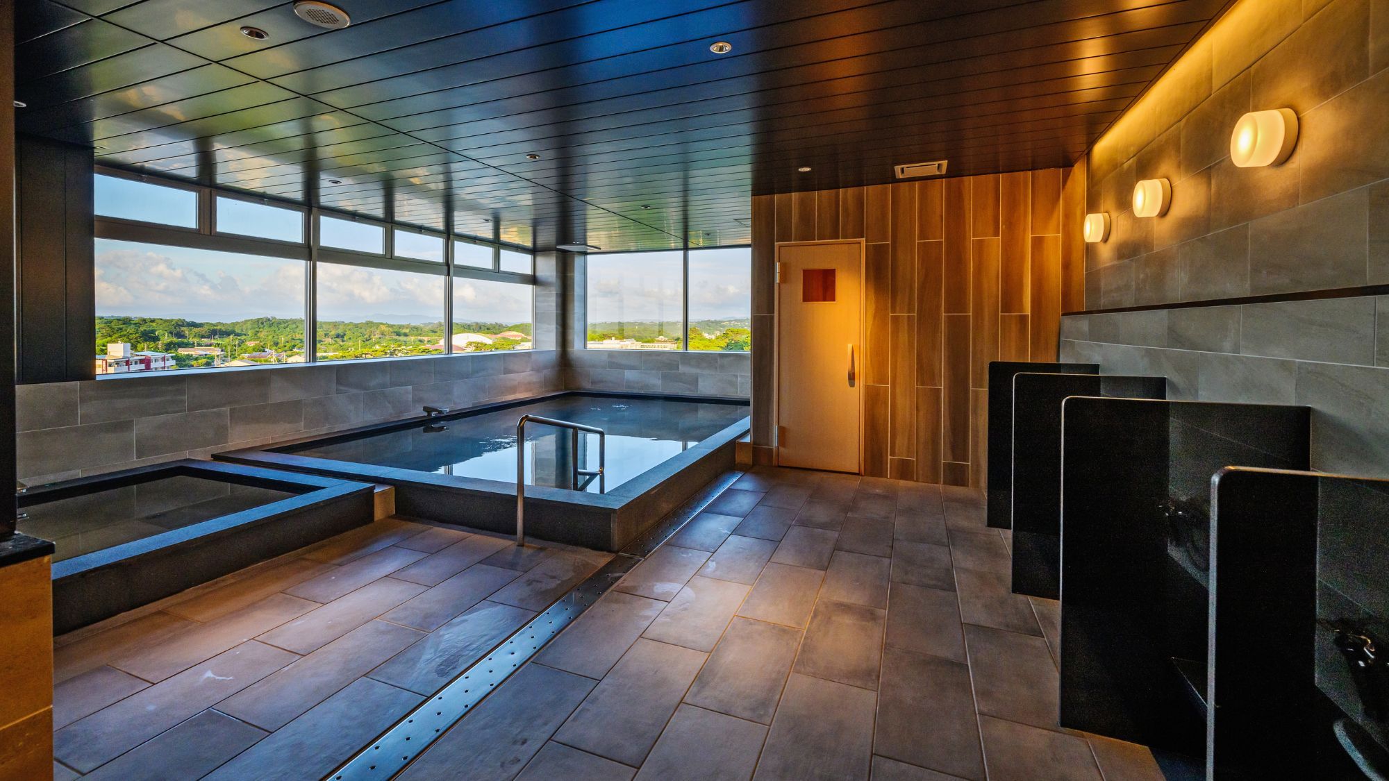 【大浴場】広々とした浴槽とサウナを完備。今帰仁の景色とともに極上のリラックスタイムを。