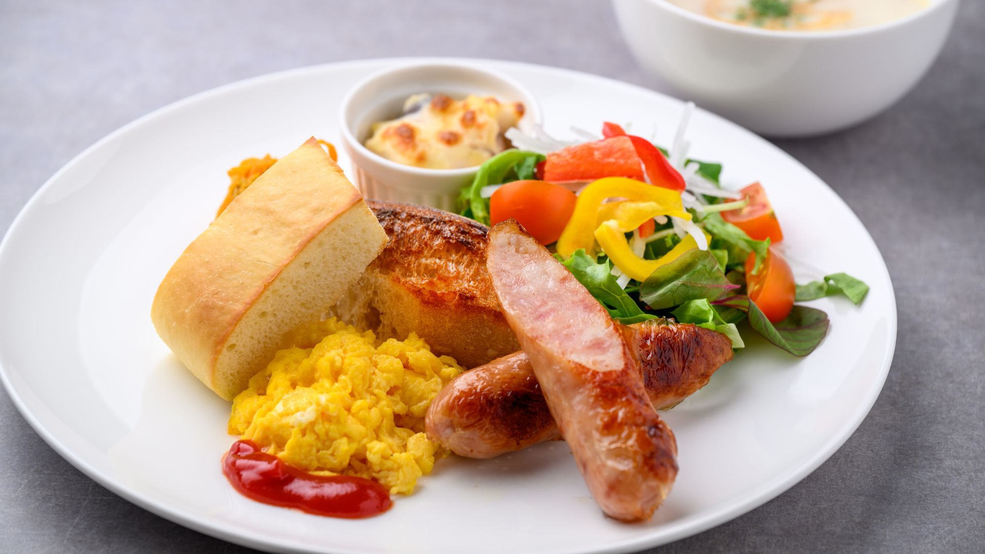 【ラウンジ/LOUNGE CAFE Lit】スクランブルエッグとソーセージのプレート。開放的な空間で