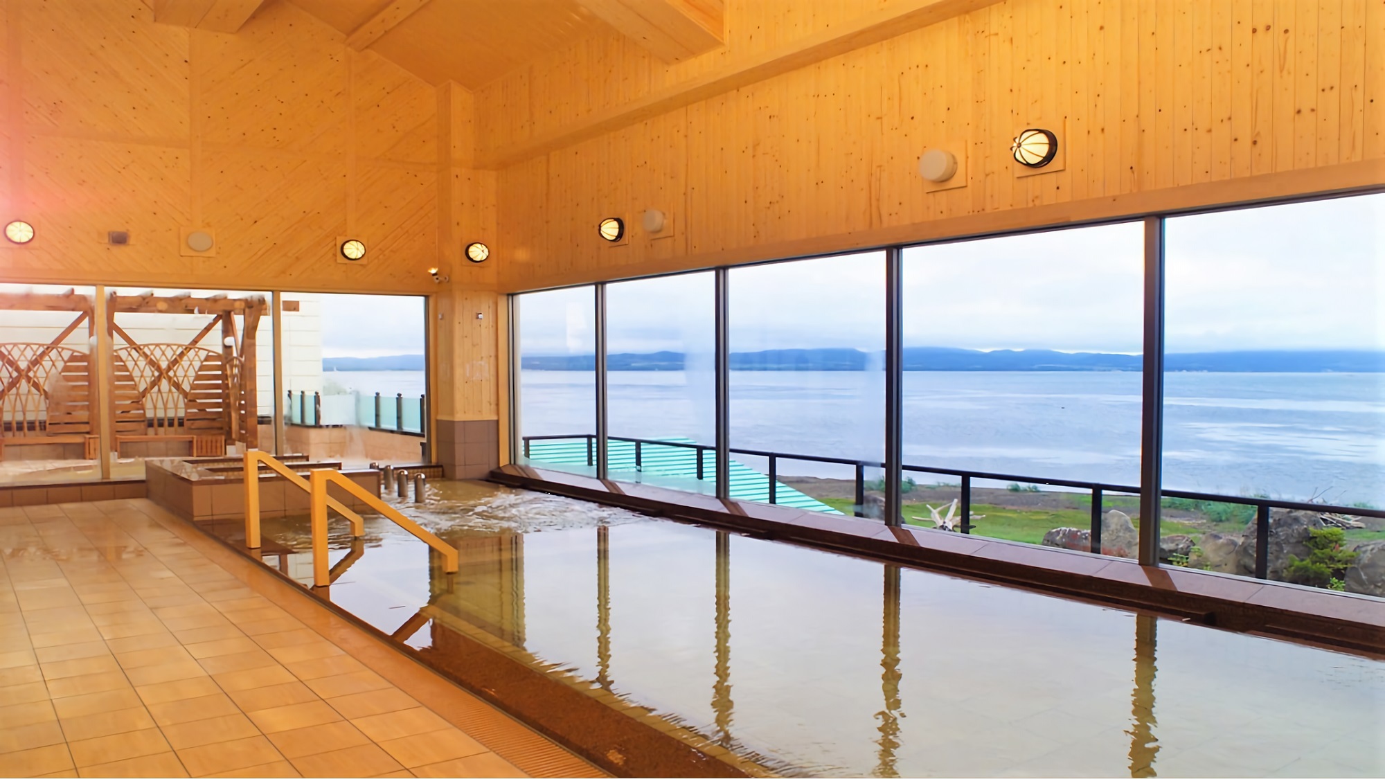 【2F北欧風大浴場（内湯）】内風呂からも露天風呂からも、雄大なサロマ湖が眺められる眺望自慢の大浴場。