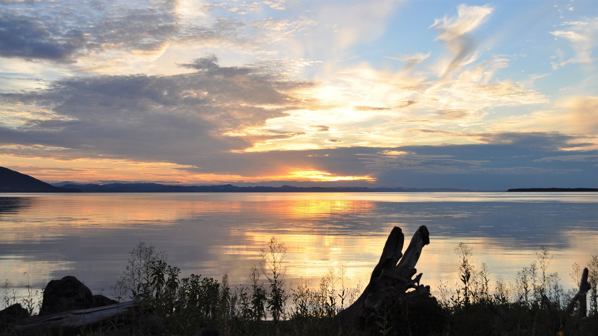 【サロマ湖の夕日（春〜秋）】日中青空が広がっていた日の夕日は、青とオレンジのコントラストが美しい。
