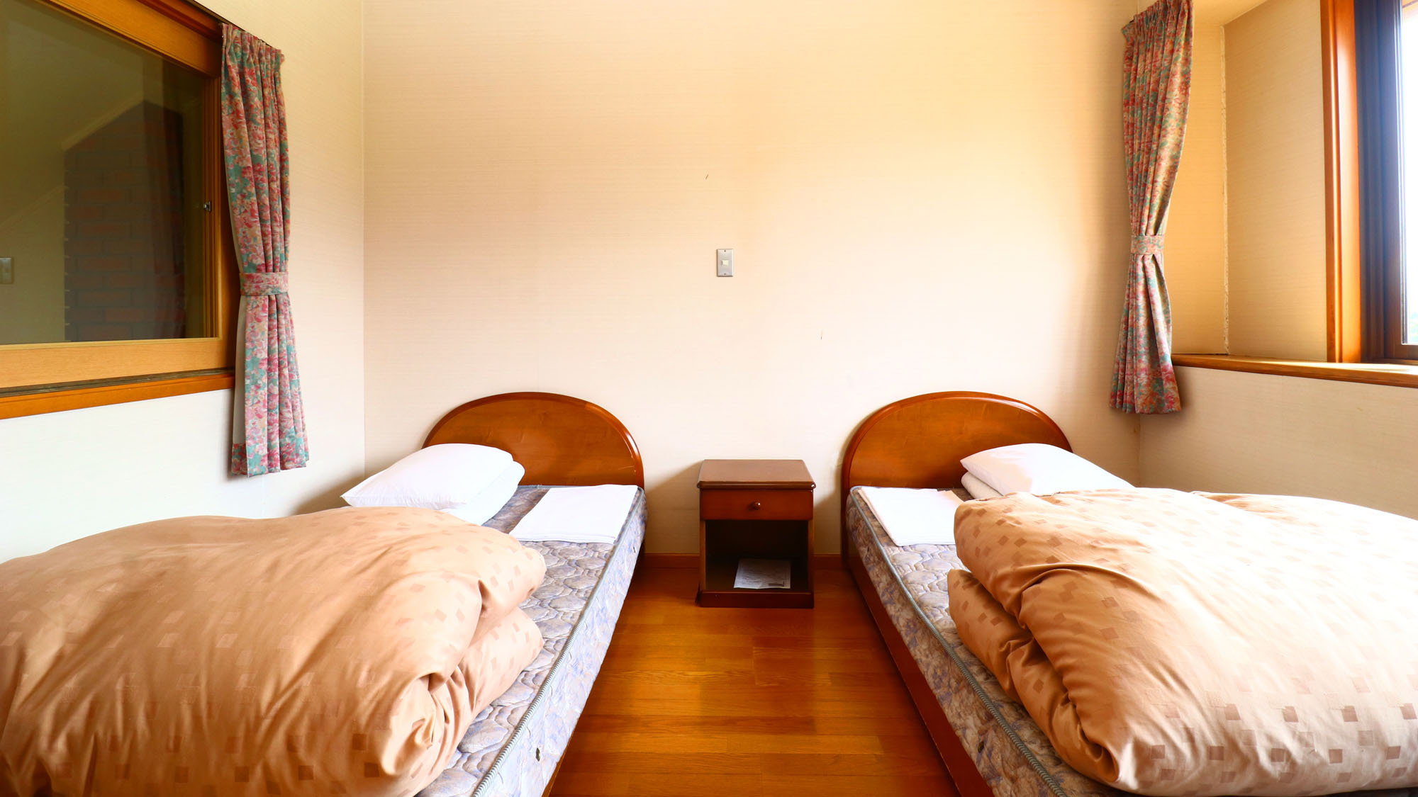 コテージ２部屋の寝室にそれぞれ２台のシングルベッドがございます。