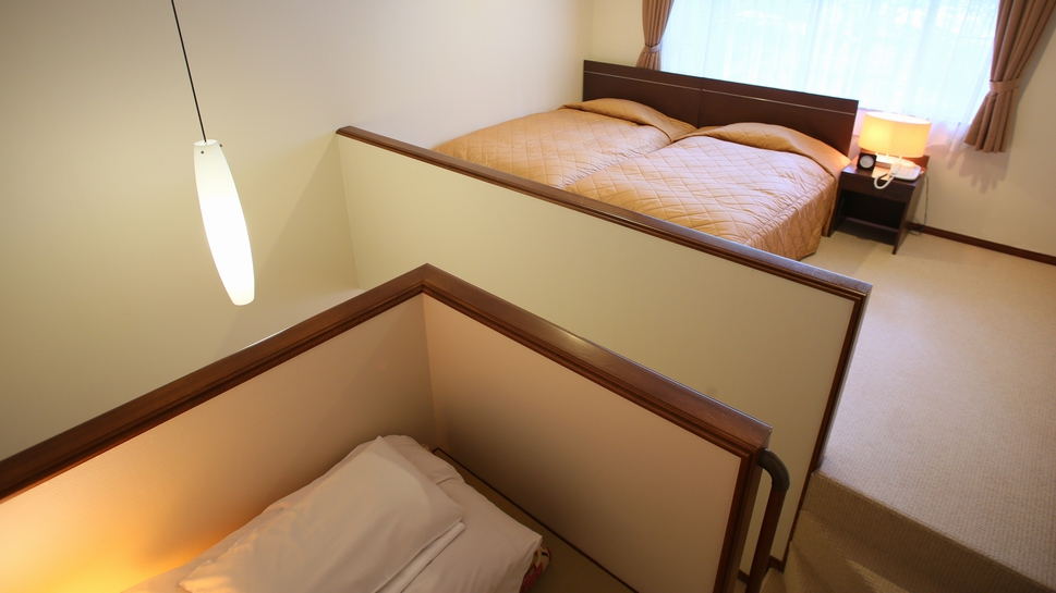 【本館メゾネット2階】ベッドルームと階段を挟んだ畳1畳分のスペース（和室ではありません。布団あり）